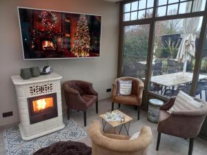 a living room with a fireplace and a christmas tree at B&B Welcome Home in Laakdal