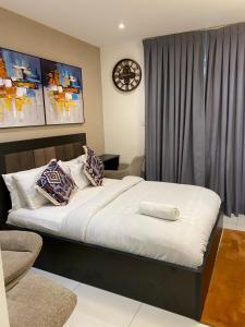 a bedroom with a large bed with pillows on it at Embassy Gardens in Accra