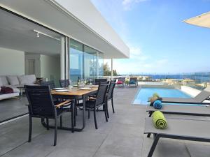 a patio with a table and chairs and a pool at AUX VILLAS DE MICK in Callao Salvaje