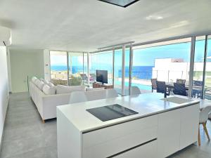 a living room with white furniture and a view of the ocean at AUX VILLAS DE MICK in Callao Salvaje