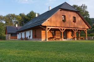 a large wooden house with a gambrel roof at Chalupa Pod Šerovnou in Prachatice