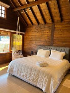 a bedroom with a large bed in a wooden room at Chalé Miragem dos Canyons in Praia Grande