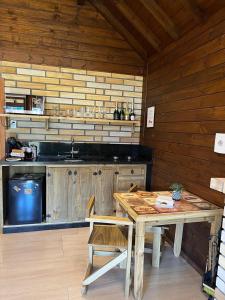 a kitchen with a table and a sink in a cabin at Chalé Miragem dos Canyons in Praia Grande +10 photos