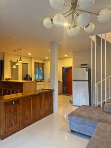 a living room with a kitchen with a refrigerator at Casa Amara in Ko Phangan