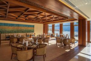 a dining room with tables and chairs and windows at Sost Serena Hotel in Gircha