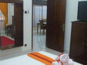 a room with a living room with a mirror and a tv at Guest House Pogung Baru in Yogyakarta