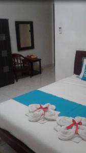 a room with two beds with towels and a table at Guest House Pogung Baru in Yogyakarta