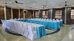 a set of tables with white chairs in a room at Mawimbi Jiko Hotel in Taveta