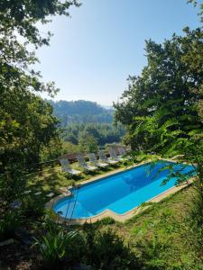 a swimming pool with lounge chairs and a view of the mountains at A Regueira Habitaciones in Alján