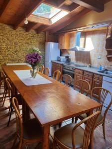 a kitchen with a wooden table and chairs at A Regueira Habitaciones in Alján