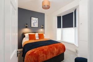 a bedroom with a bed with orange pillows at Cosy Anfield Home in Liverpool