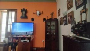 a living room with orange walls and a flat screen tv at Wahnon Guesthouse in Paul