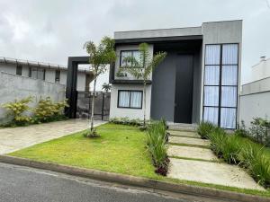 a house with a grass yard in front of it at Angra casa in Angra dos Reis
