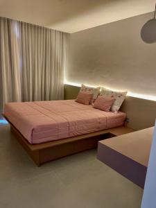 a bedroom with a bed with pink sheets and pillows at Angra casa in Angra dos Reis +19 photos