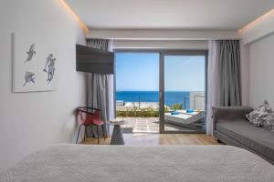 ein Schlafzimmer mit Bett und Meerblick in der Unterkunft Adrina Grand Hotel in Panormos Skopelos + 142 Fotos