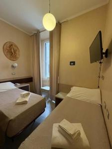 a hotel room with two beds and a flat screen tv at Hotel Elide in Rome