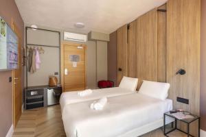 a bedroom with a white bed and a wooden wall at B&B Hotel Genova City Center in Genoa +26 photos