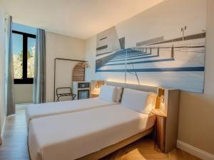 a bedroom with a bed with a painting on the wall at B&B Hotel Firenze City Center in Florence