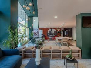a lobby with a waiting room with benches and tables at B&B Hotel Firenze City Center in Florence