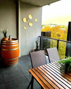a balcony with a wooden table and a large barrel at Bliss in Braddon in Braddon
