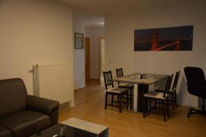 a living room with a table and chairs and a couch at Exklusive Wohnung mit Garten in Niederdorla