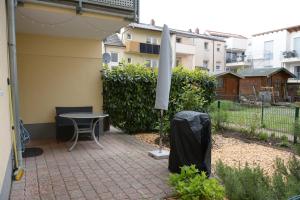 a patio with a table and an umbrella at Exklusive Wohnung mit Garten in Niederdorla