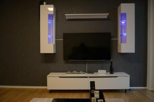 a living room with a tv and a white table at Exklusive Wohnung mit Garten in Niederdorla