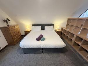 a bedroom with a bed with white sheets and shelves at Millbrook House Apartments 2 in Milton