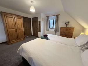 a bedroom with a large white bed and a window at Millbrook House Apartments 2 in Milton