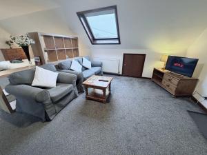 a living room with a couch and a tv at Millbrook House Apartments 2 in Milton +9 photos