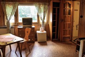a room with a tv and a table and a window at Camping Pod Krokwią in Zakopane