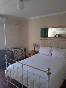 a bedroom with a white bed and a stove at De Kothuize 4 in Graaff-Reinet