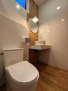 a bathroom with a white toilet and a sink at Casa Amara in Ko Phangan