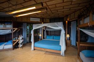 a bedroom with a blue bed and two bunk beds at The Rock Lodge in Ban Nahin-Nai (1)