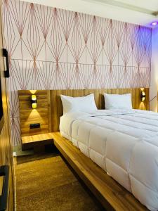 a bedroom with a large white bed and a wall at DAKHLA RELAX Appartement Idéal Pour Familles & Voyageurs in Dakhla