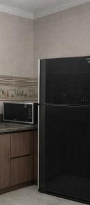 a kitchen with a black refrigerator and a microwave at Evermond Suites in Alexandria