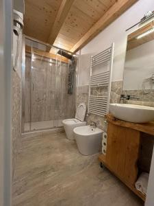 a bathroom with two sinks and a toilet and a shower at Loft bridge in Ascoli Piceno