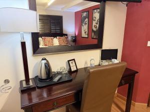 a desk with a telephone and a lamp on it at @Grace Guesthouse in Klerksdorp