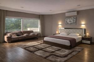a bedroom with a bed and a couch at Evermond Suites in Alexandria