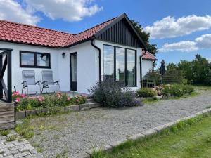a white cottage with a red roof at Stendala Gård in Gärsnäs