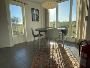 a dining room with a table and chairs and windows at Stendala Gård in Gärsnäs +26 photos
