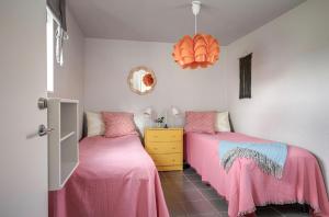 two beds in a room with pink sheets at Stendala Gård in Gärsnäs