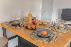 a table with plates of food and wine glasses at Appart lumineux, WIFI haut débit, proche gare 7 min, Lyon 15 min in Couzon-au-Mont-dʼOr