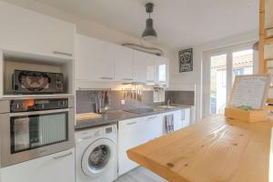 a kitchen with white appliances and a wooden table at Appart lumineux, WIFI haut débit, proche gare 7 min, Lyon 15 min in Couzon-au-Mont-dʼOr
