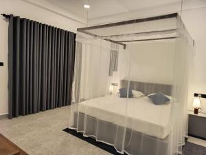 a bedroom with a canopy bed with blue pillows at The BLISS Mihiripenna in Talpe +12 photos