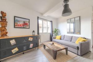 a living room with a couch and a table at Appart lumineux, WIFI haut débit, proche gare 7 min, Lyon 15 min in Couzon-au-Mont-dʼOr +14 photos
