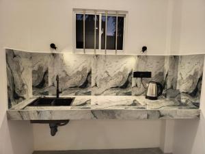 a kitchen with a marble counter top with a sink at The BLISS Mihiripenna in Talpe