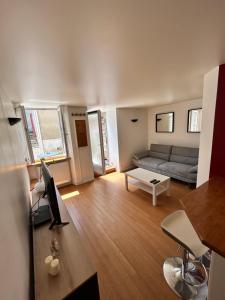 a living room with a couch and a table at studio confort seine port in Seine-Port