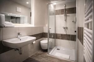 a bathroom with a sink and a toilet and a shower at Ata Hotel - Self Check-in in Hamburg +24 photos