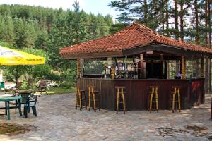 a bar with stools in front of a building at Hotel Zora in Velingrad